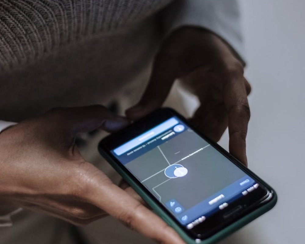 Photo by Ron Lach Transporte Araque Coslada Madrid - Close-up of a woman holding a smartphone with GPS navigation displayed, emphasizing technology and connectivity.
